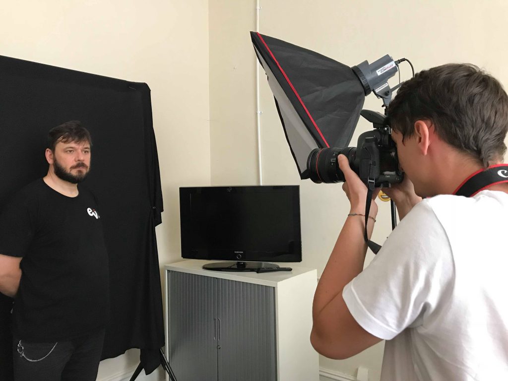 Liam, volunteer, taking photos at a staff photo shot.