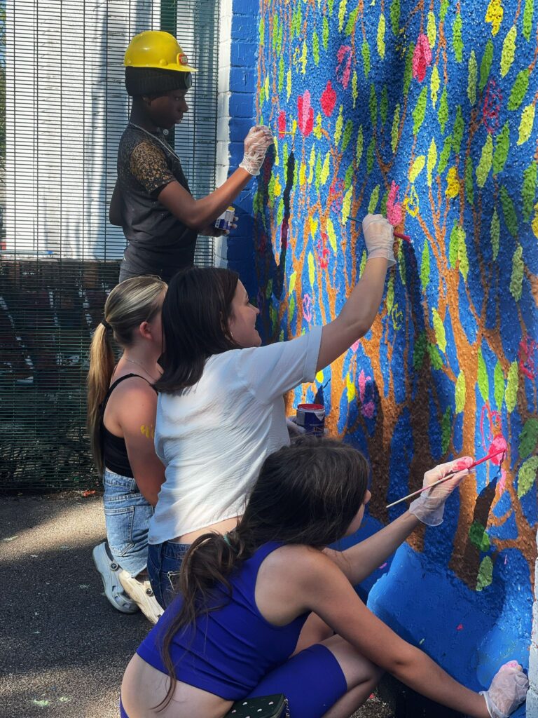 4 young people from North Ely Youth Club painting the mural