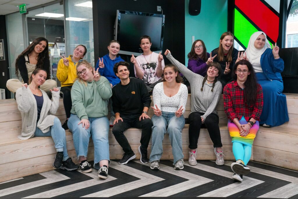 Group photograph of Mind Our Future Gwent peer researchers and staff, all looking happy and pulling funny faces.