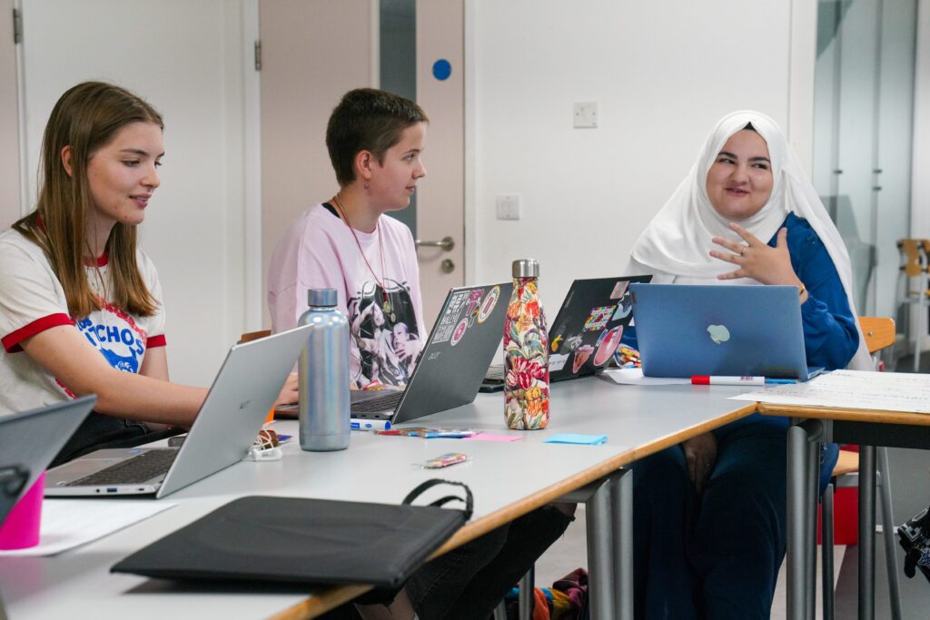 Three young people working together using laptops