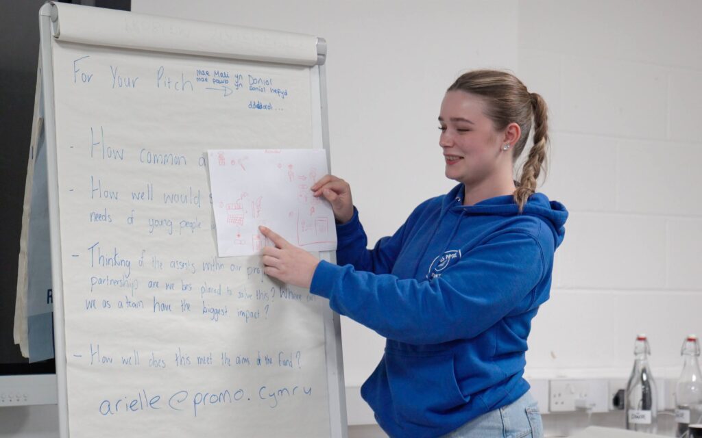 One young person presenting using flip chart paper.