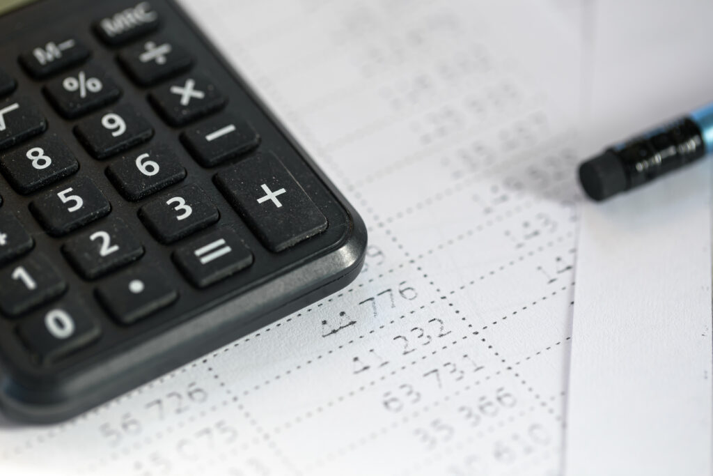 Calculator and pencil close-up on a blurred background, the concept of tax calculations and finance.